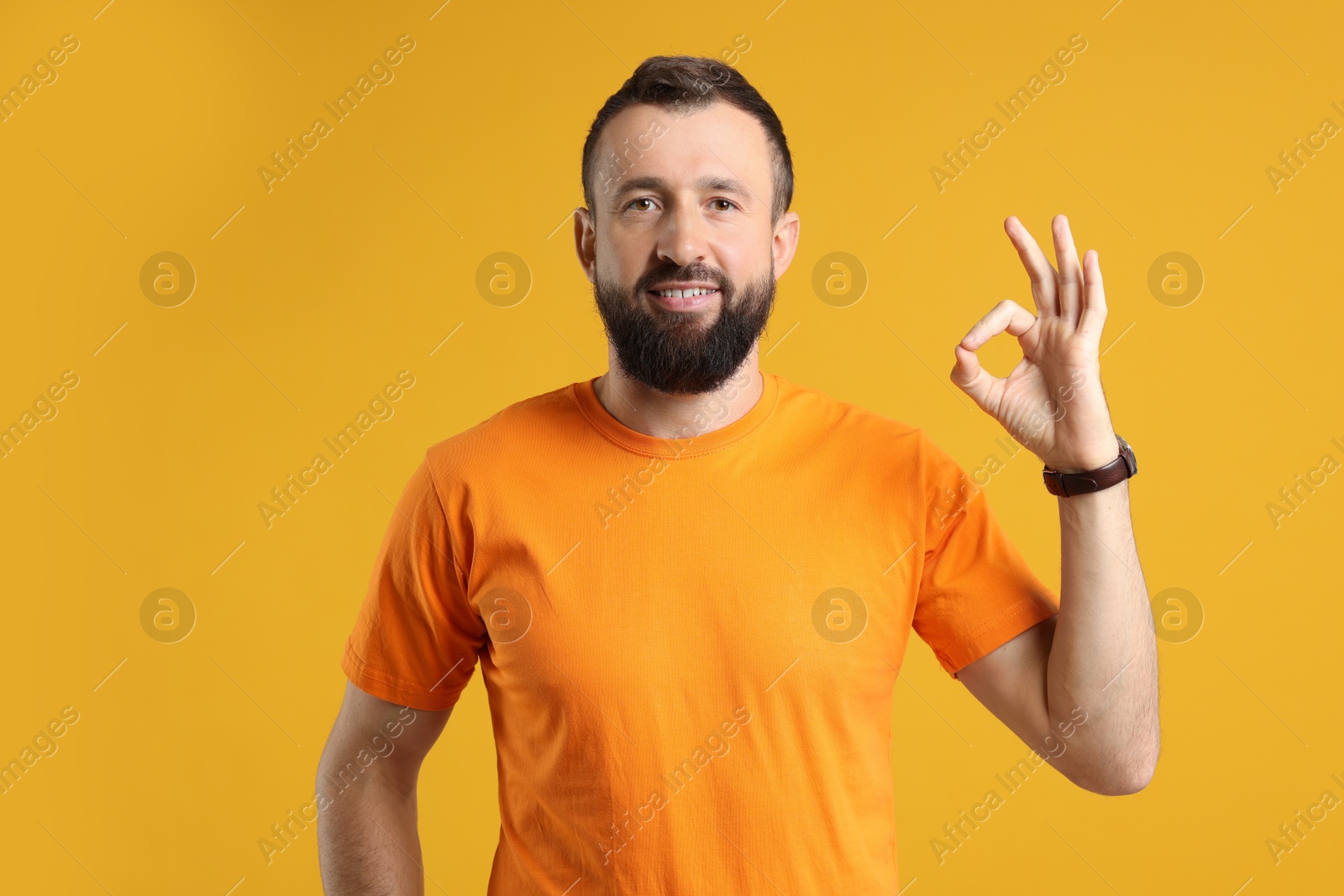 Photo of Man showing okay gesture on orange background