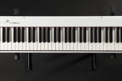 Photo of Synthesizer on black background, top view. Electronic musical instrument