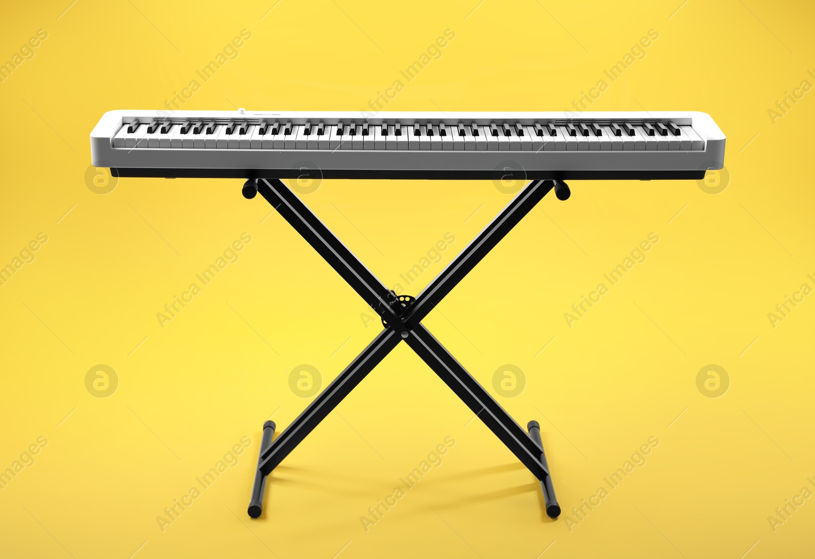 Photo of Synthesizer on yellow background. Electronic musical instrument