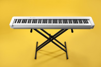 Photo of Synthesizer on yellow background. Electronic musical instrument