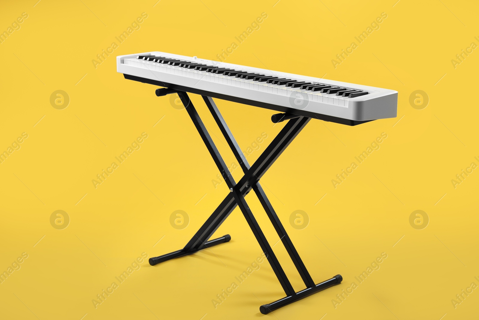 Photo of Synthesizer on yellow background. Electronic musical instrument