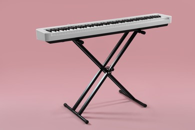 Photo of Synthesizer on pink background. Electronic musical instrument