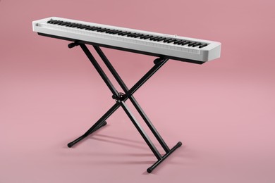 Photo of Synthesizer on pink background. Electronic musical instrument