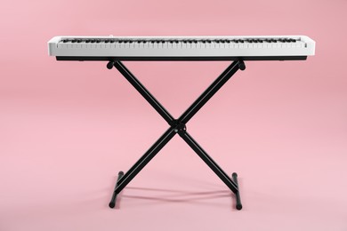 Photo of Synthesizer on pink background. Electronic musical instrument