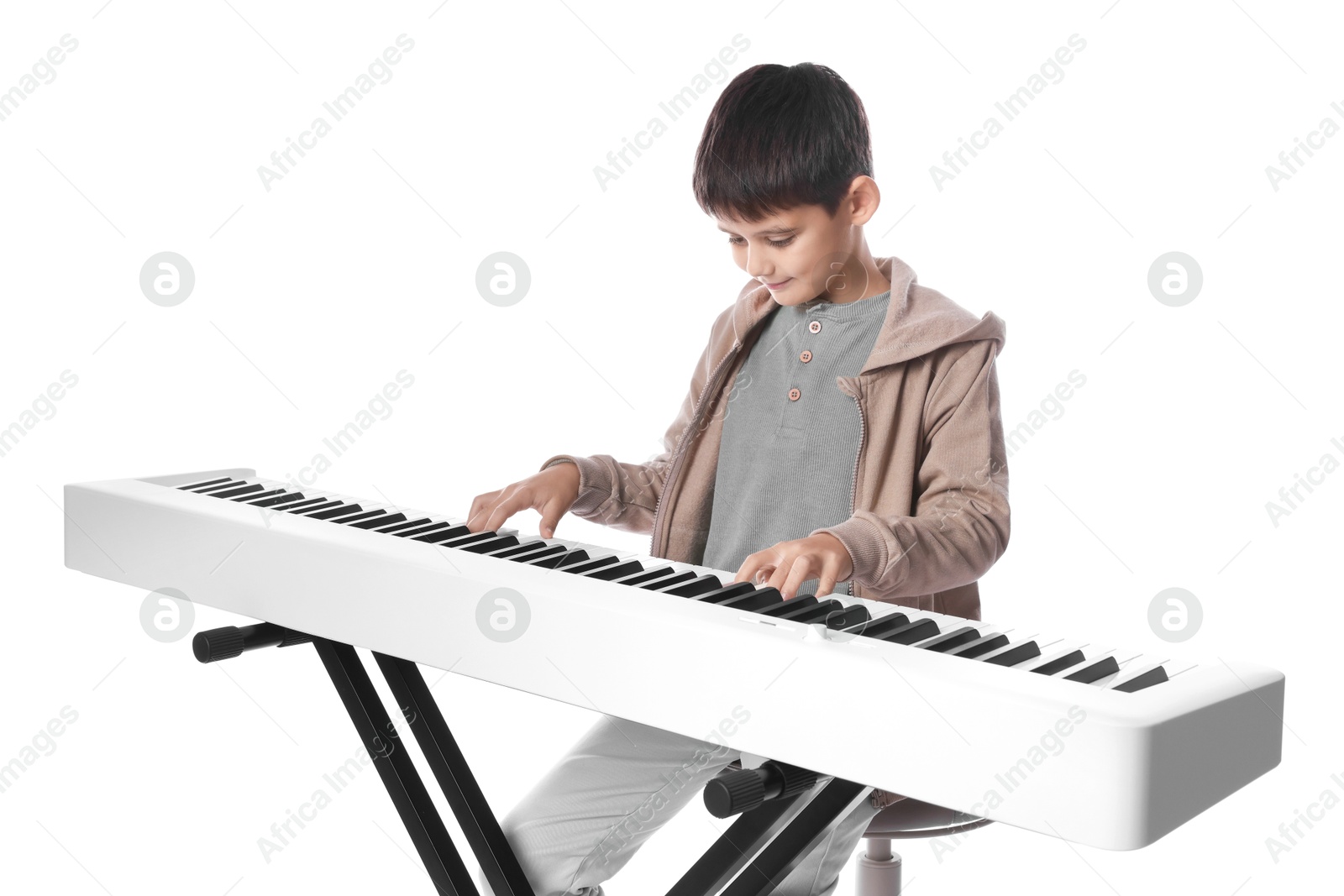 Photo of Cute boy playing synthesizer on white background