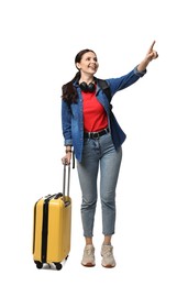 Photo of Young tourist with suitcase pointing at something on white background