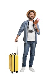 Photo of Happy tourist in hat with suitcase, passport and ticket on white background