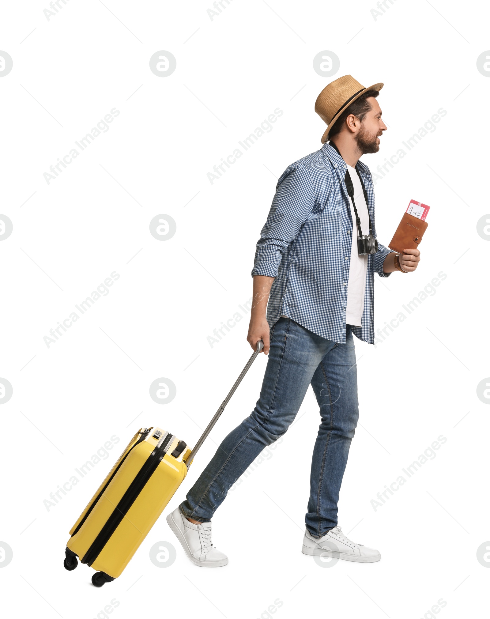 Photo of Happy tourist in hat with suitcase, passport and ticket on white background