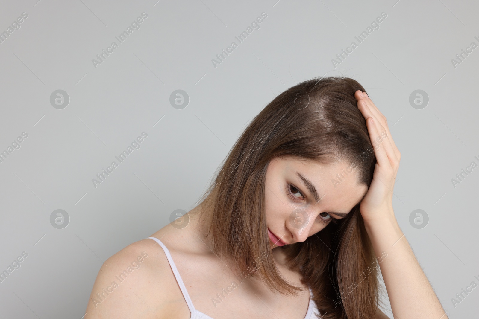 Photo of Girl with hair loss problem on grey background