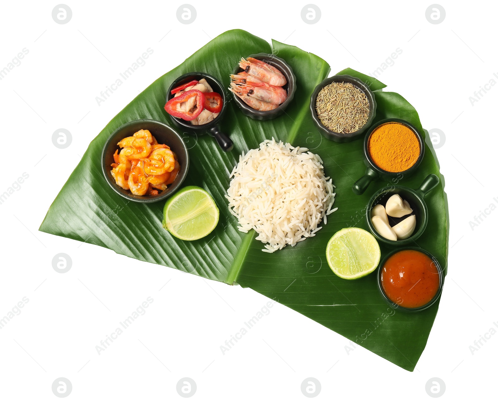 Photo of Cut banana leaf with different food, spices and sauce isolated on white, top view. Healthy eco serving