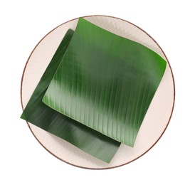 Photo of Pieces of banana leaves isolated on white, top view. Traditional meal serving