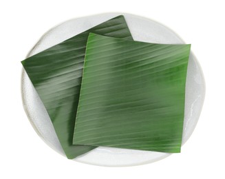 Photo of Pieces of banana leaves isolated on white, top view. Traditional meal serving