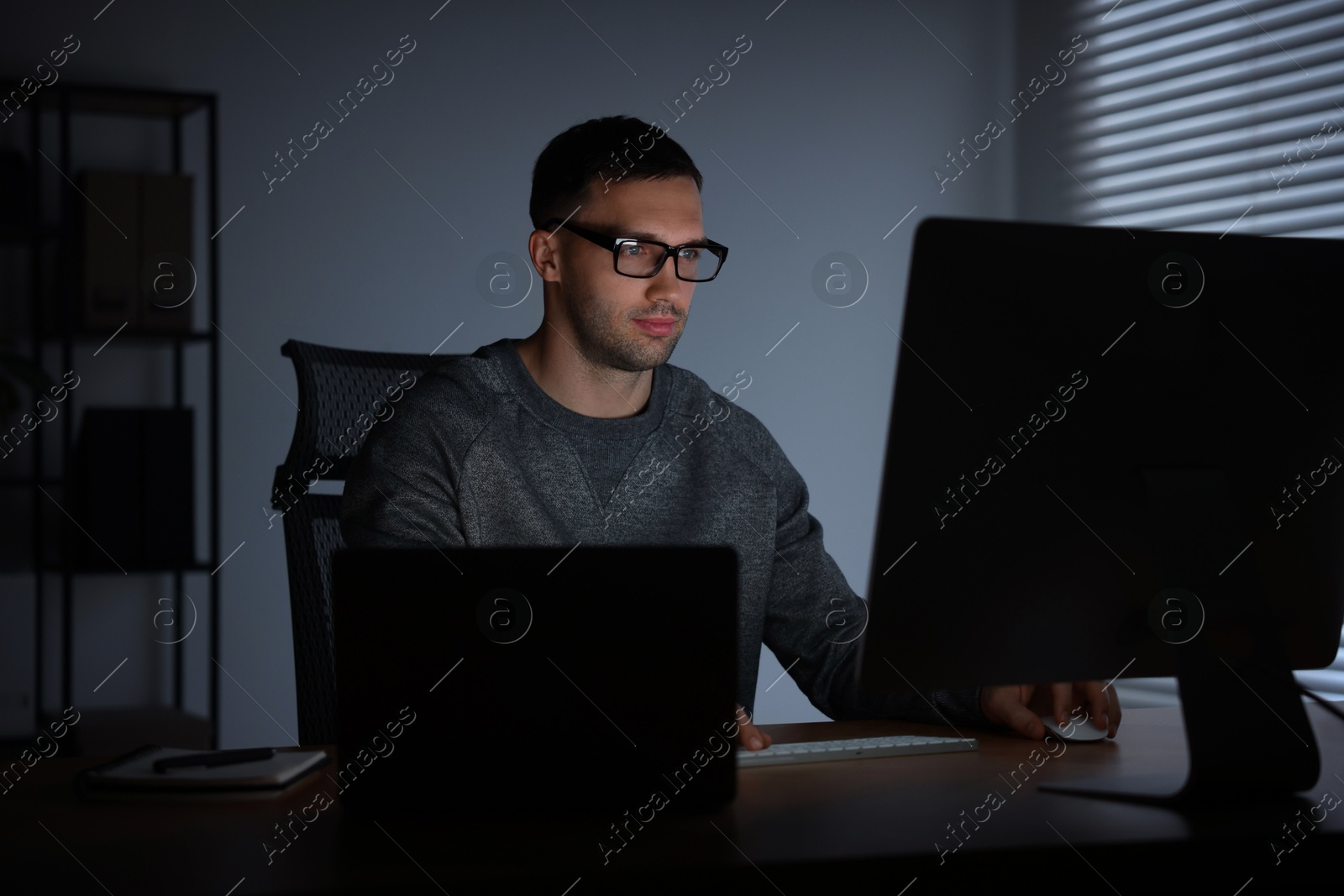 Photo of Programmer working on computer indoors at night