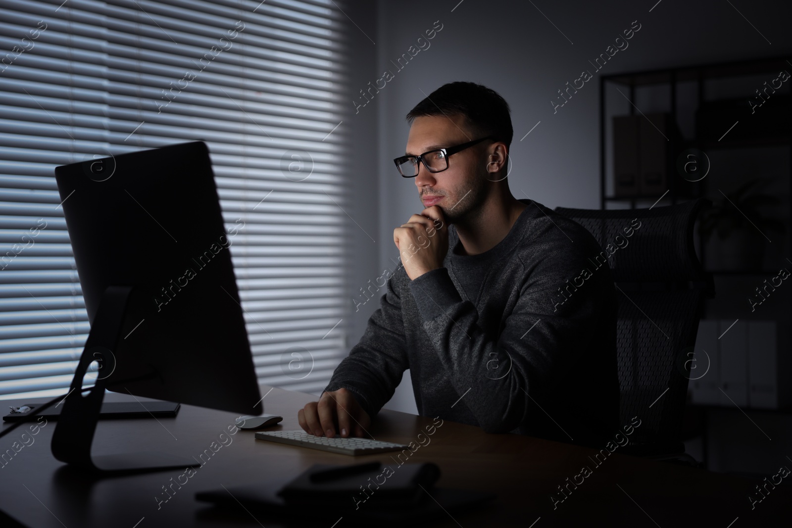 Photo of Programmer working on computer indoors at night