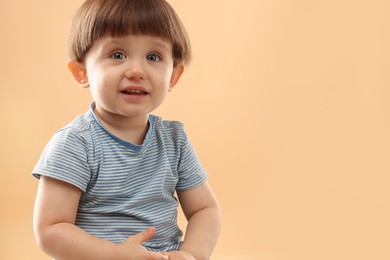 Photo of Portrait of cute little boy on beige background. Space for text