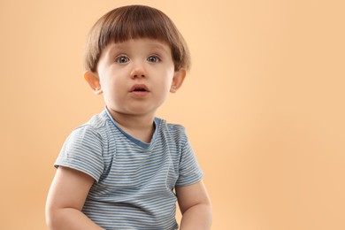 Photo of Portrait of cute little boy on beige background. Space for text