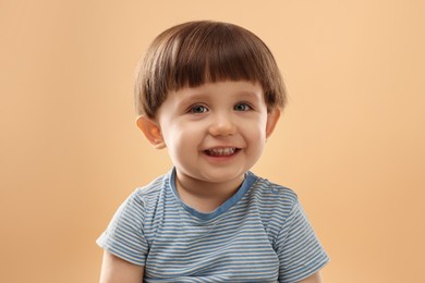 Photo of Portrait of happy little boy on beige background