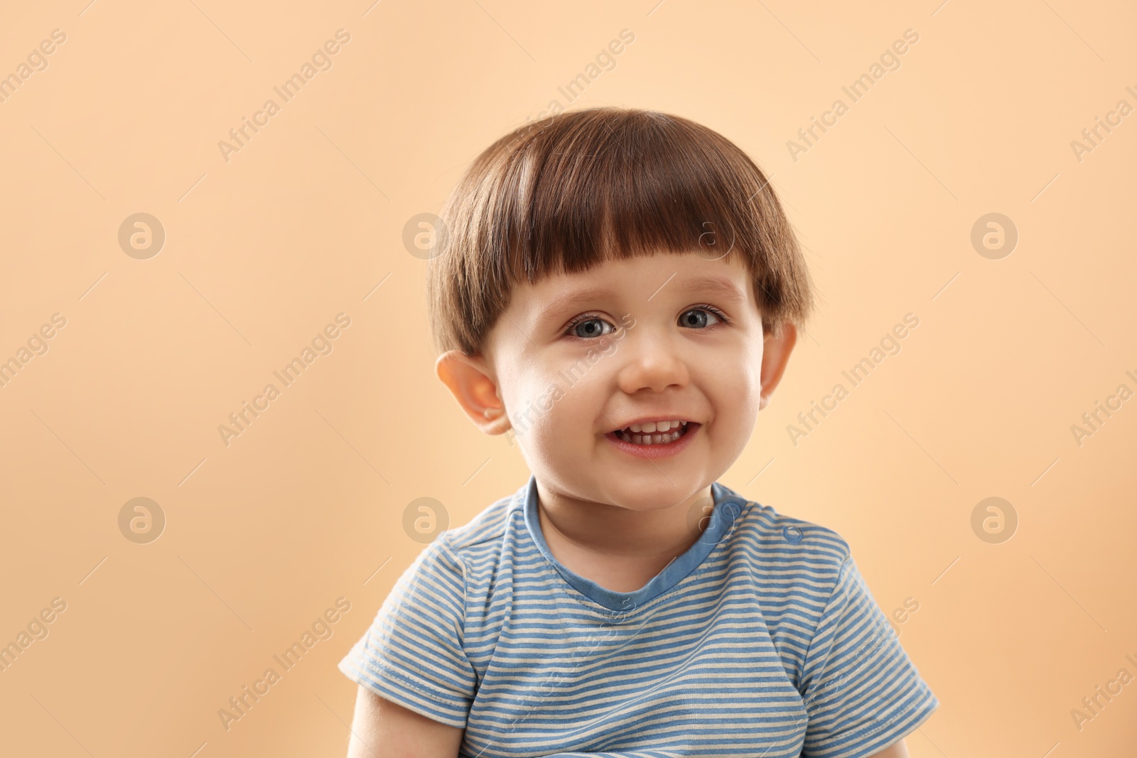 Photo of Portrait of happy little boy on beige background