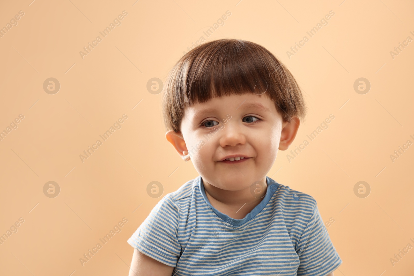 Photo of Portrait of happy little boy on beige background