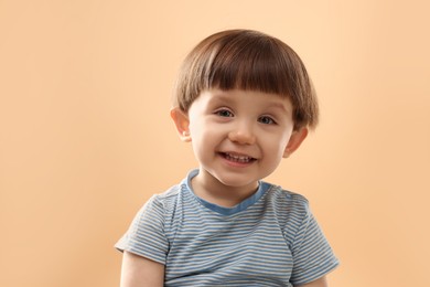 Photo of Portrait of happy little boy on beige background