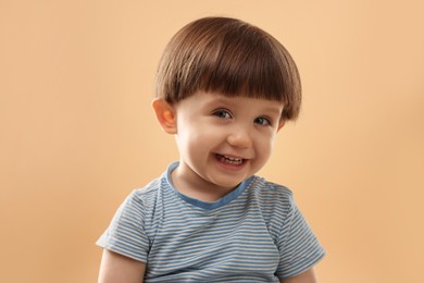 Photo of Portrait of happy little boy on beige background