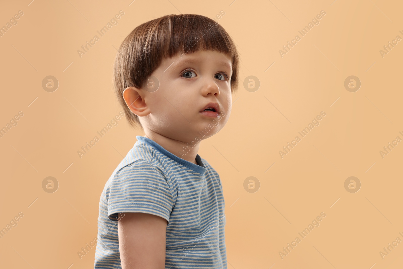 Photo of Portrait of cute little boy on beige background. Space for text