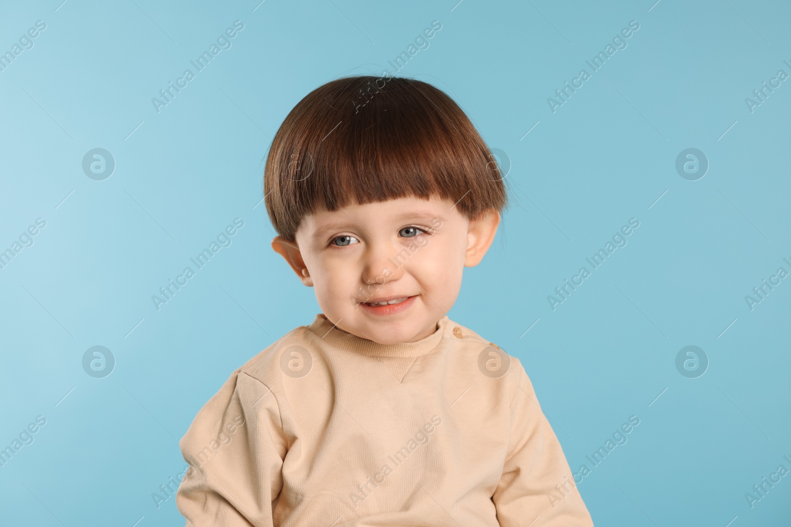 Photo of Portrait of smiling little boy on light blue background