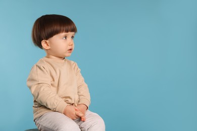 Photo of Portrait of cute little boy on light blue background. Space for text