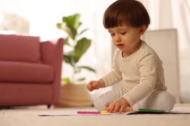 Photo of Cute little boy drawing on floor at home, space for text