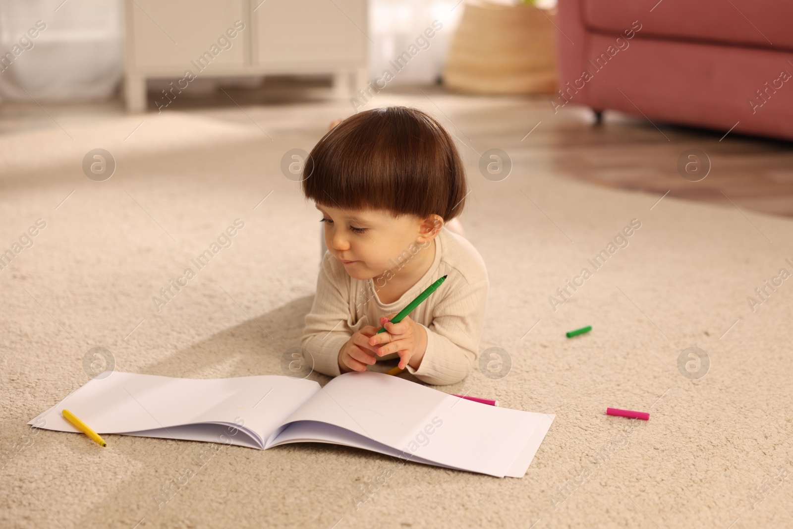 Photo of Cute little boy drawing on floor at home, space for text