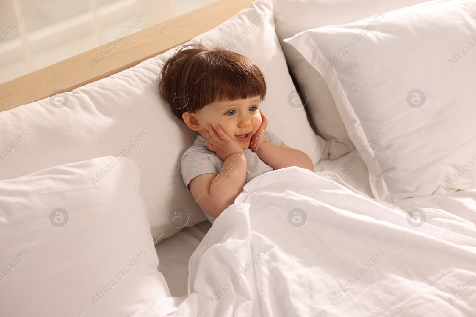 Photo of Cute little boy in bed at home