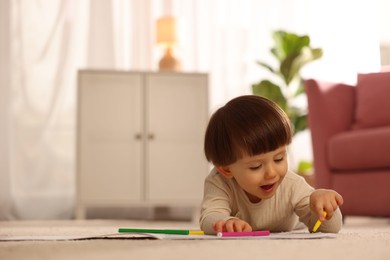 Photo of Cute little boy drawing on floor at home, space for text