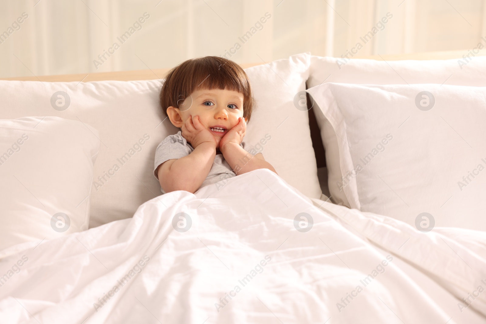 Photo of Cute little boy in bed at home