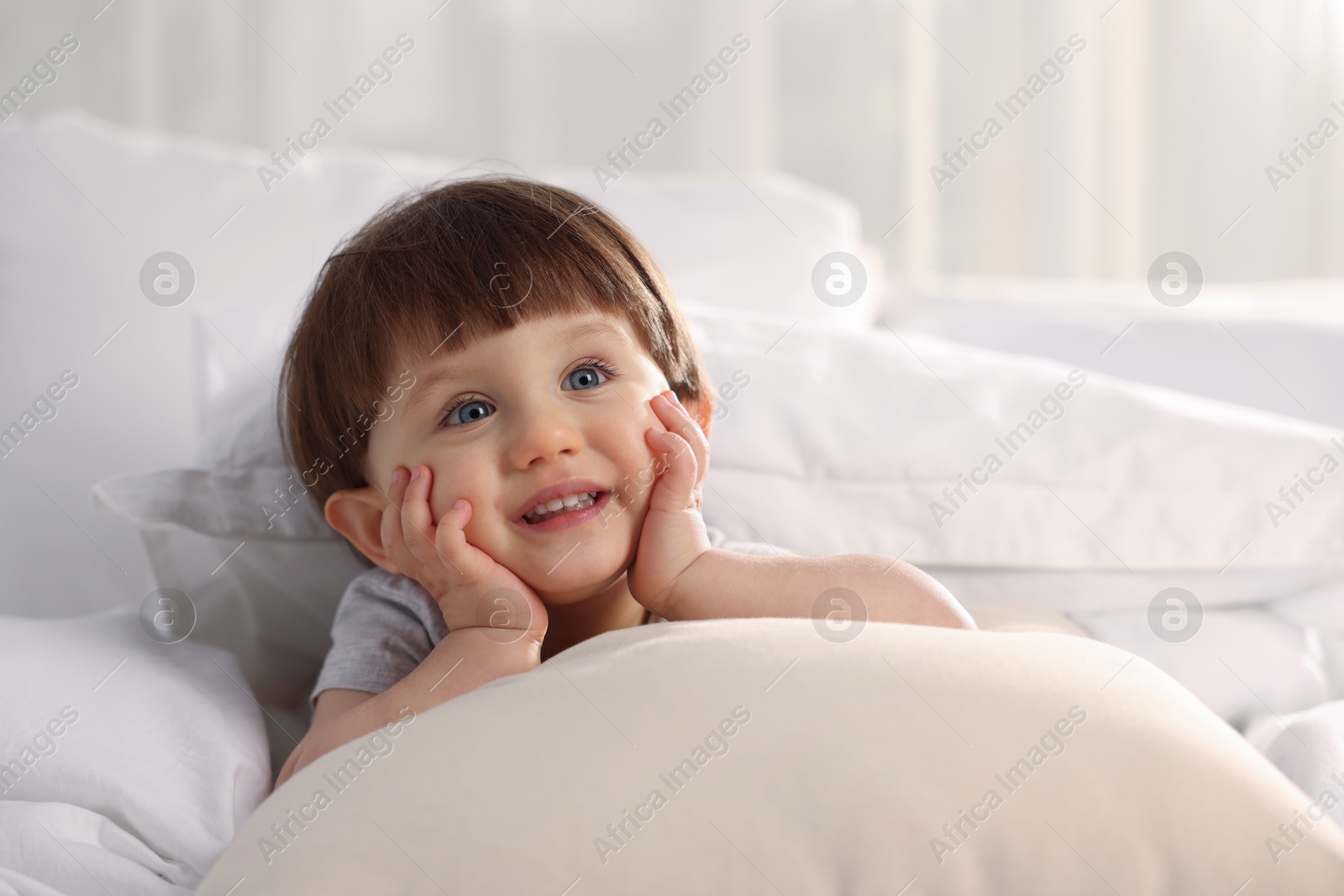 Photo of Cute little boy in bed at home