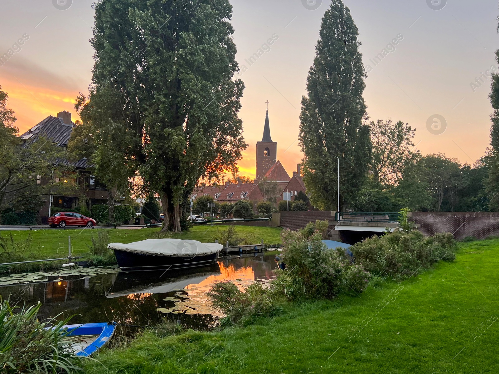 Photo of Picturesque view of canal with moored boats on sunset