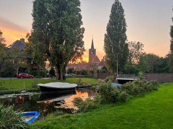 Photo of Picturesque view of canal with moored boats on sunset