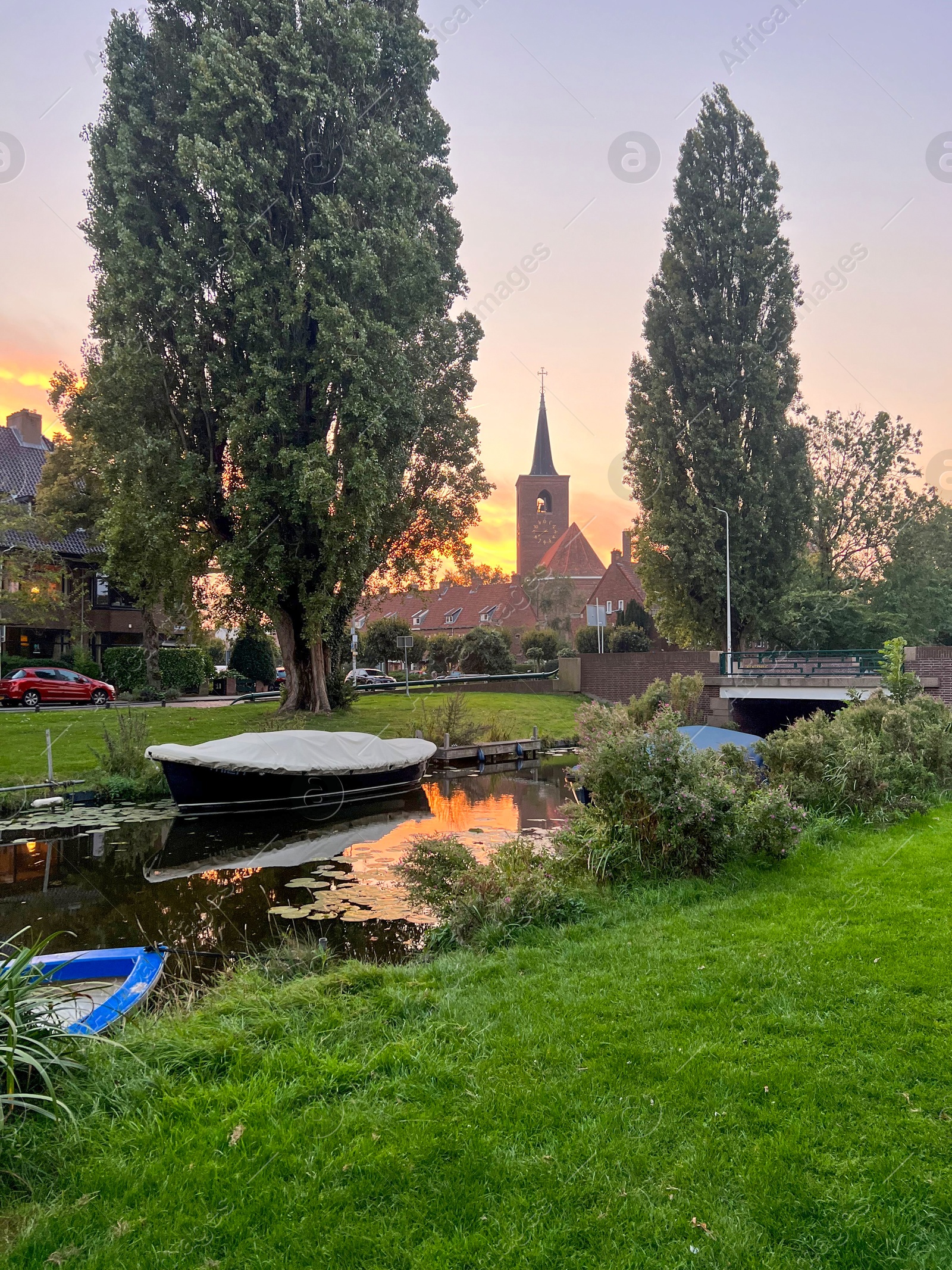 Photo of Picturesque view of canal with moored boats on sunset