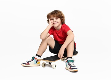 Photo of Little boy with skateboard on white background