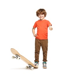 Photo of Little boy with skateboard showing thumbs up on white background