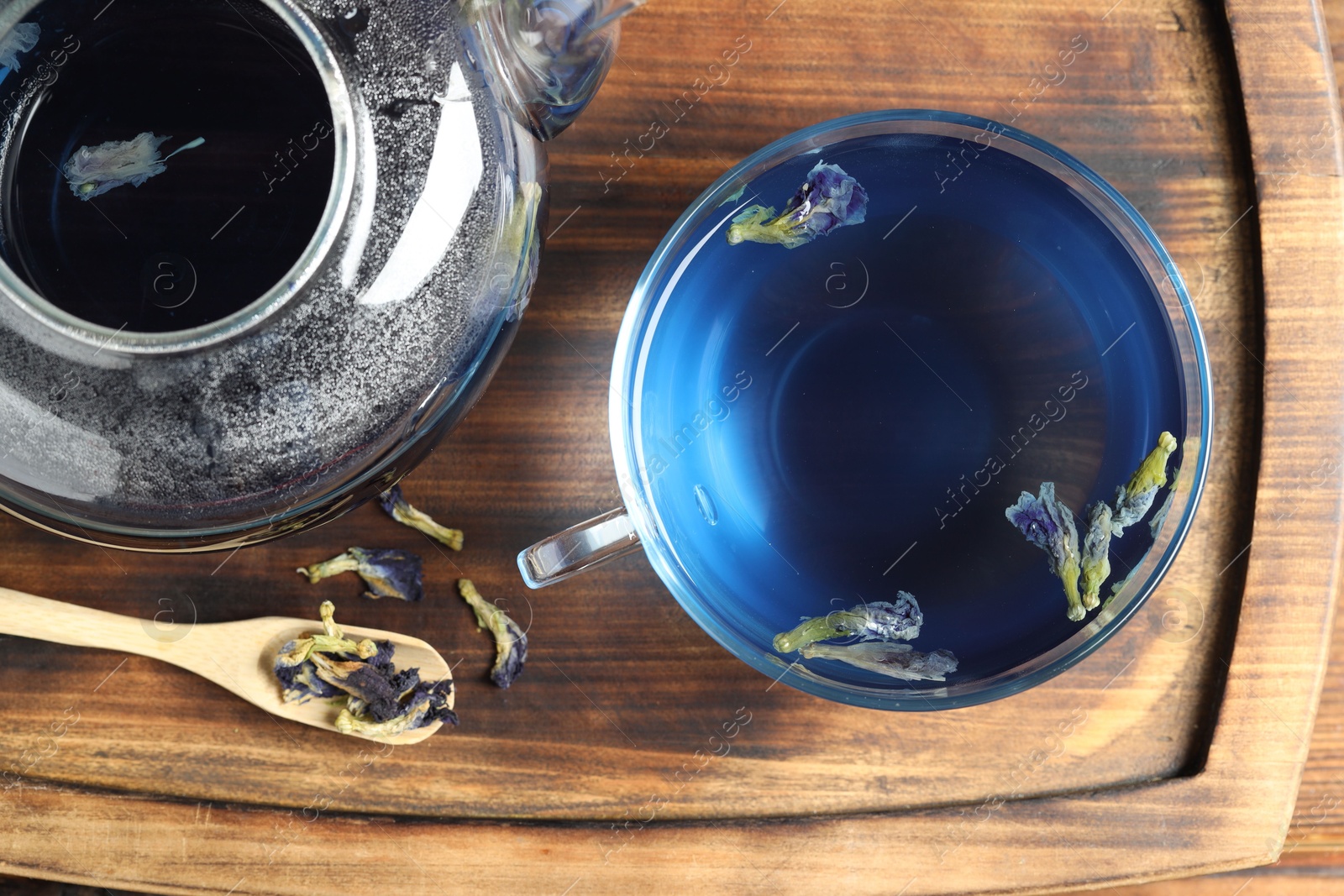 Photo of Delicious butterfly pea flower tea on wooden table, top view