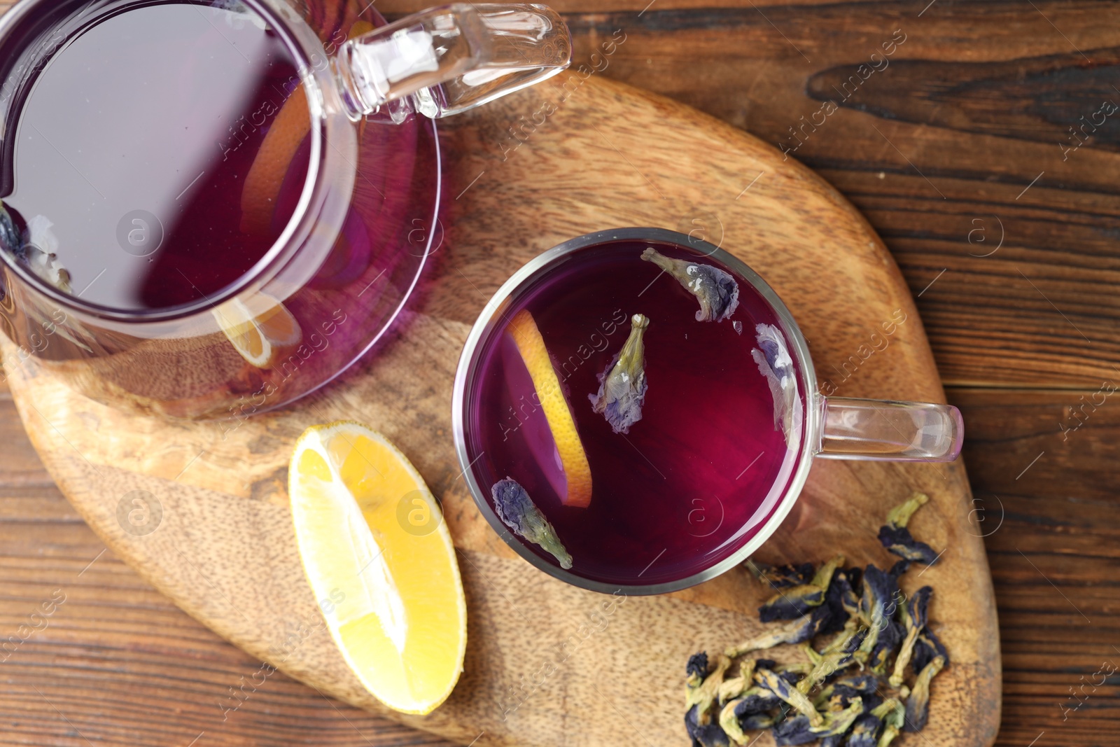 Photo of Delicious butterfly pea flower tea with lemon on wooden table, top view