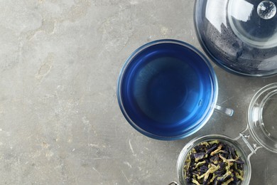 Photo of Delicious butterfly pea flower tea on gray textured table, flat lay. Space for text