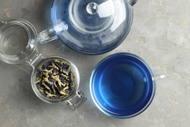 Photo of Delicious butterfly pea flower tea on gray textured table, flat lay