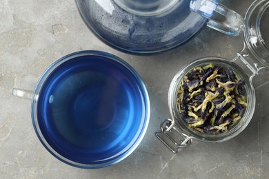 Photo of Delicious butterfly pea flower tea on gray textured table, flat lay