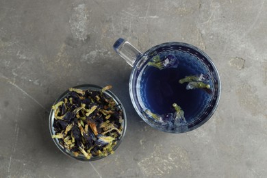 Photo of Delicious butterfly pea flower tea on gray textured table, flat lay