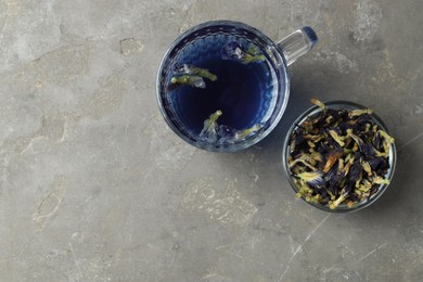 Photo of Delicious butterfly pea flower tea on gray textured table, flat lay. Space for text