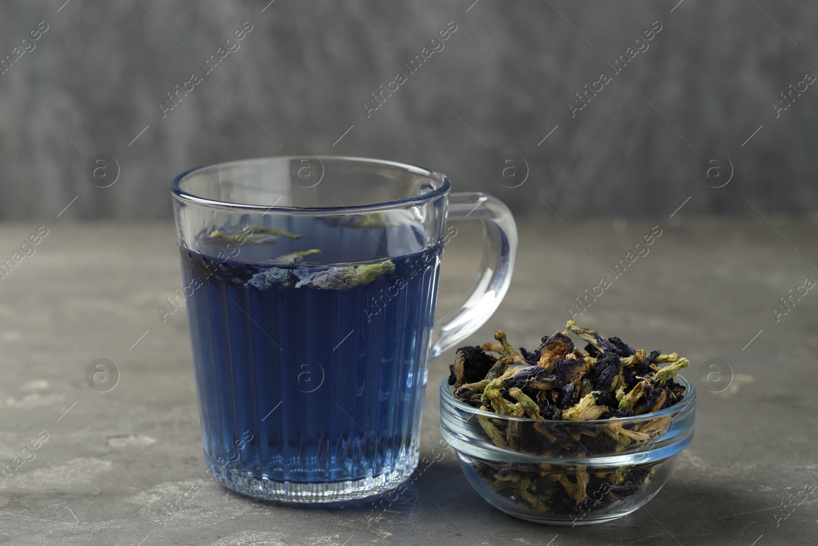 Photo of Delicious butterfly pea flower tea on gray textured table