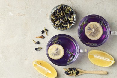 Photo of Delicious butterfly pea flower tea with lemon on gray textured table, flat lay. Space for text