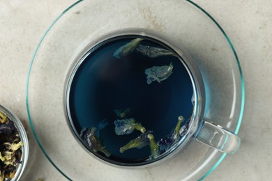 Photo of Delicious butterfly pea flower tea on gray textured table, top view