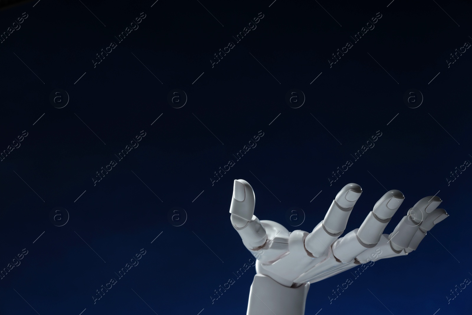 Photo of Artificial intelligence. Robot hand gesturing on dark blue background, space for text